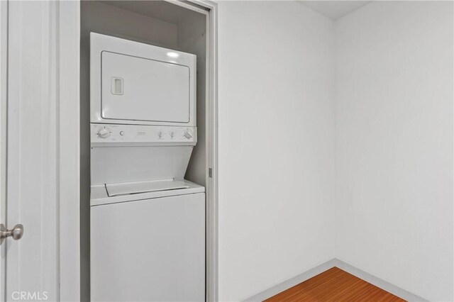 630 W 6th St Unit 215, Los Angeles, CA 90017 - laundry area featuring estacked washer and dryer, baseboards, and wood finished floors