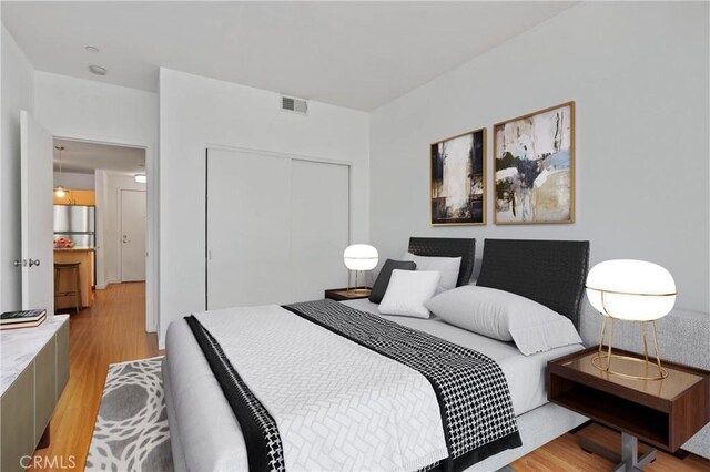 630 W 6th St Unit 215, Los Angeles, CA 90017 - bedroom featuring light wood-style floors, a closet, and freestanding refrigerator