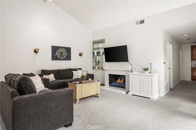 2726 Torrey Pine Dr Unit 12, Fullerton, CA 92835 - living room featuring light colored carpet, a brick fireplace, high vaulted ceiling, and baseboards