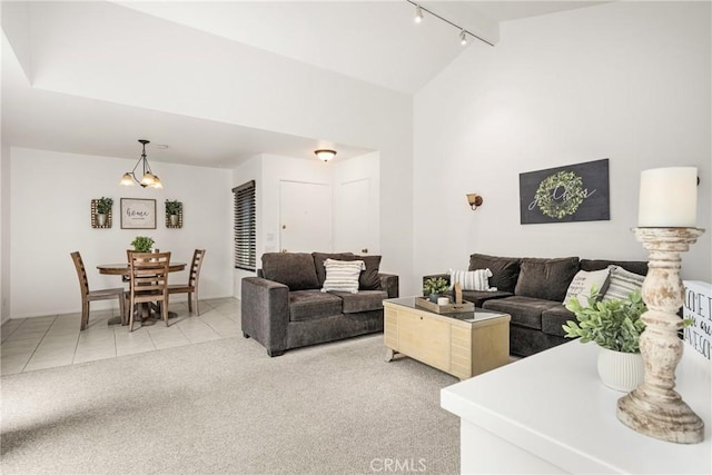 2726 Torrey Pine Dr Unit 12, Fullerton, CA 92835 - living area featuring track lighting, vaulted ceiling, light tile patterned floors, light colored carpet, and a chandelier