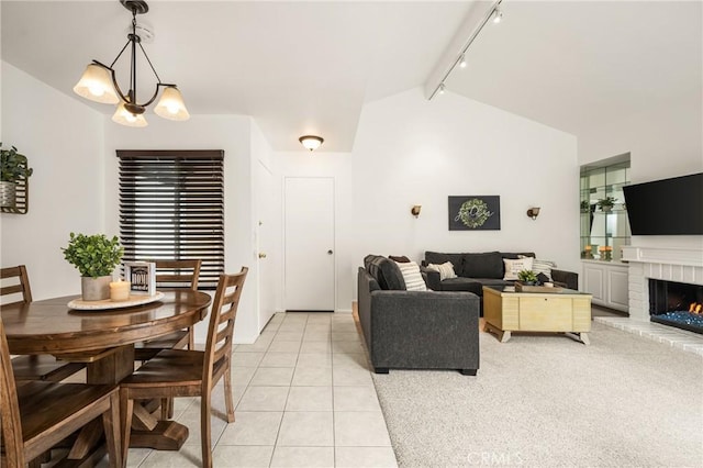 2726 Torrey Pine Dr Unit 12, Fullerton, CA 92835 - living area featuring track lighting, lofted ceiling, light tile patterned flooring, and a brick fireplace
