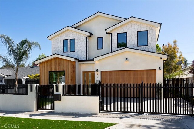 22640 Clarendon St, Woodland Hills, CA 91367 - contemporary house featuring stone siding, an attached garage, a fenced front yard, and stucco siding