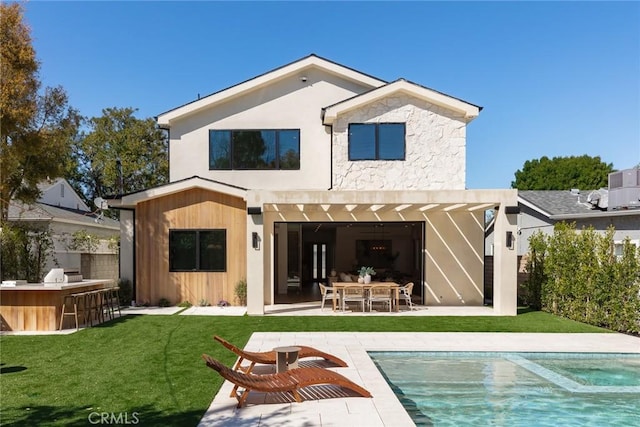 22640 Clarendon St, Woodland Hills, CA 91367 - rear view of house featuring a patio, a pool with connected hot tub, an outdoor kitchen, and stone siding