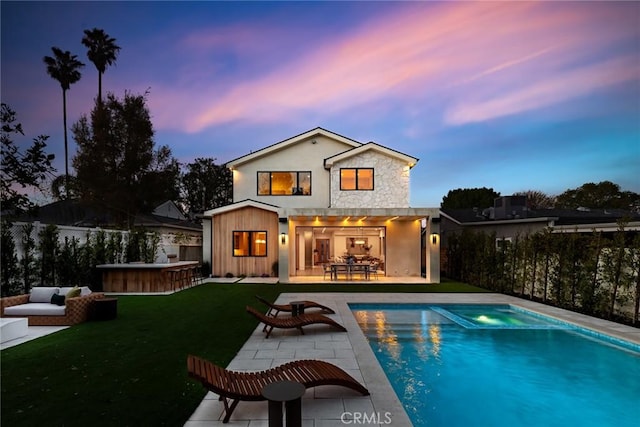 22640 Clarendon St, Woodland Hills, CA 91367 - rear view of property with a patio area, an outdoor hangout area, stone siding, and a pool with connected hot tub