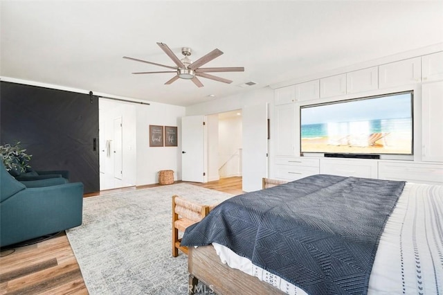 4326 Forest Ranch Rd, Oceanside, CA 92057 - bedroom featuring a barn door, light wood finished floors, and a ceiling fan