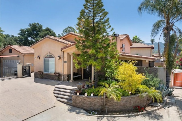 10610 Oak Tree Way, Sunland, CA 91040 - mediterranean / spanish house with a gate, stucco siding, a tile roof, and stone siding