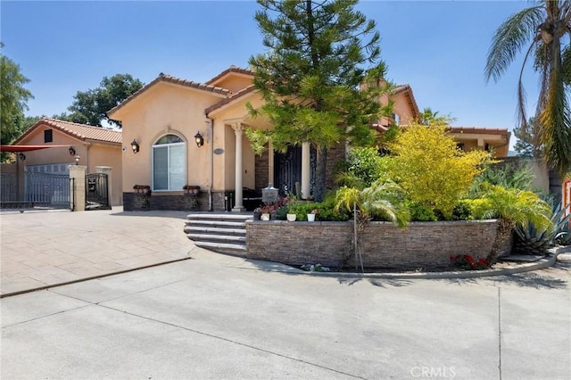 10610 Oak Tree Way, Sunland, CA 91040 - mediterranean / spanish-style house with stucco siding, a tile roof, and a gate