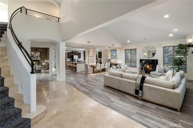 3141 Hillrose Dr, Rossmoor, CA 90720 - living area with stairs, a fireplace, high vaulted ceiling, arched walkways, and recessed lighting