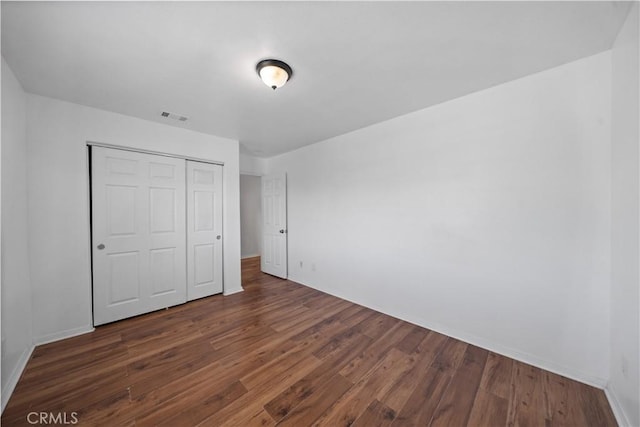 1568 Burns Ln, San Jacinto, CA 92335 - unfurnished bedroom featuring dark wood-style flooring, a closet, and baseboards