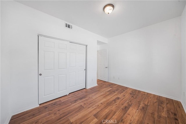1568 Burns Ln, San Jacinto, CA 92335 - unfurnished bedroom with hardwood / wood-style flooring, baseboards, and a closet