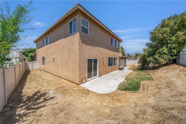 1568 Burns Ln, San Jacinto, CA 92335 - rear view of house with a fenced backyard, a patio, and stucco siding