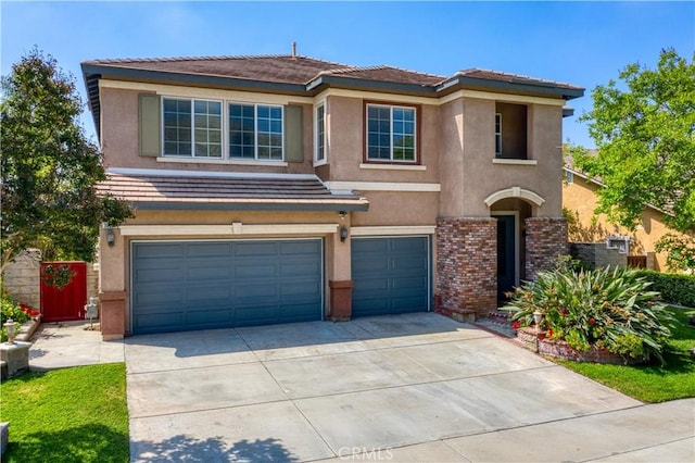 30185 Tenaya Ln, Highland, CA 92346 - view of front of home with an attached garage, concrete driveway, and stucco siding