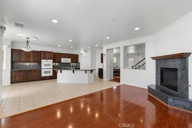 30185 Tenaya Ln, Highland, CA 92346 - kitchen featuring white appliances, open floor plan, light wood-style flooring, ornamental molding, and recessed lighting