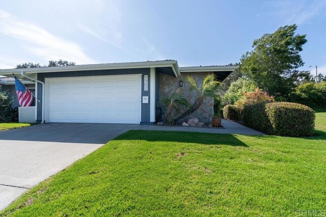 1302 El Corral Ln, San Marcos, CA 92078 - view of front of property featuring a front lawn, driveway, stone siding, and an attached garage
