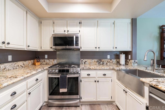1302 El Corral Ln, San Marcos, CA 92078 - kitchen featuring appliances with stainless steel finishes, white cabinetry, and light stone counters