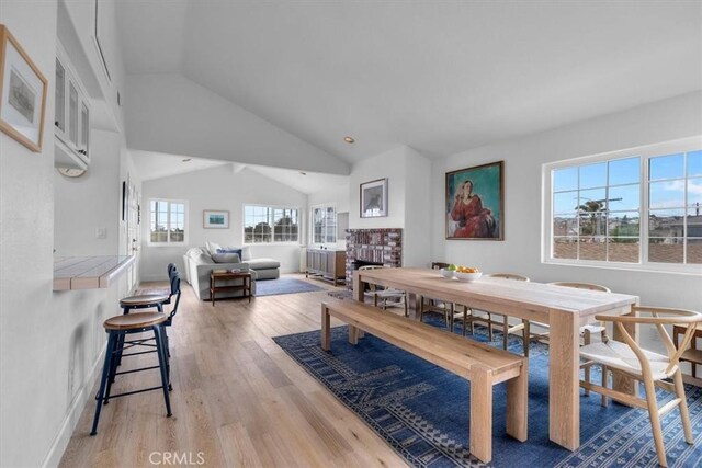 320 W 19th St Unit 1, San Pedro, CA 90731 - dining room with lofted ceiling, light wood-style flooring, a fireplace, and baseboards