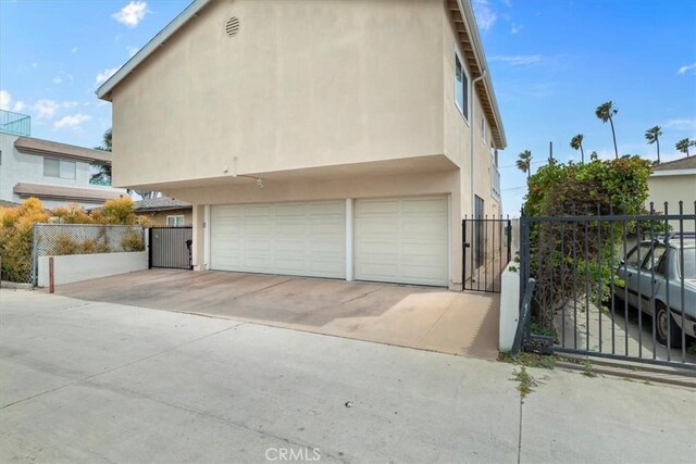 320 W 19th St Unit 1, San Pedro, CA 90731 - view of side of property featuring stucco siding, a gate, and a garage