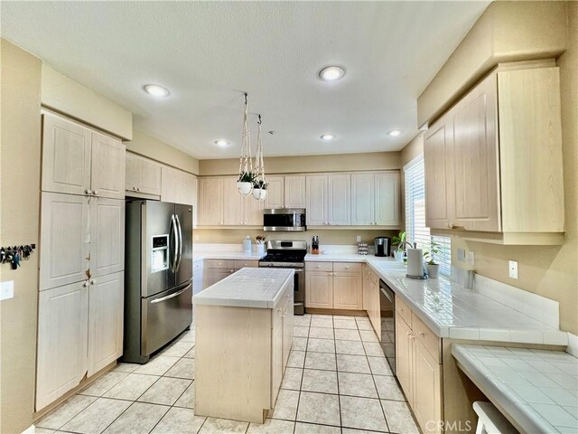 5890 Kendrick Dr, Riverside, CA 92507 - kitchen featuring appliances with stainless steel finishes, tile countertops, a kitchen island, recessed lighting, and light tile patterned floors