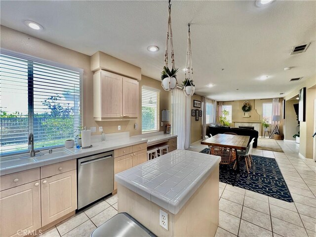 5890 Kendrick Dr, Riverside, CA 92507 - kitchen with stainless steel dishwasher, tile counters, open floor plan, light tile patterned floors, and light brown cabinets