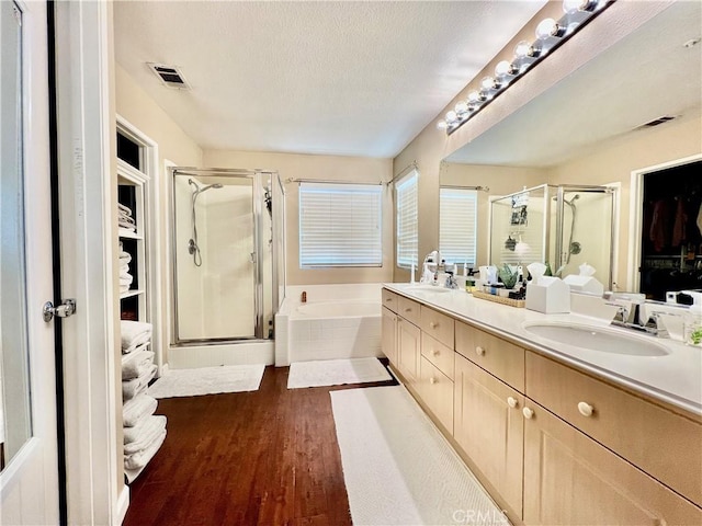 5890 Kendrick Dr, Riverside, CA 92507 - full bathroom with a stall shower, double vanity, a bath, wood finished floors, and a textured ceiling