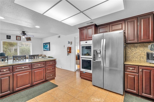 20043 Emerald Meadow Dr, Walnut, CA 91789 - kitchen with appliances with stainless steel finishes, ceiling fan, light tile patterned flooring, tasteful backsplash, and dark brown cabinets