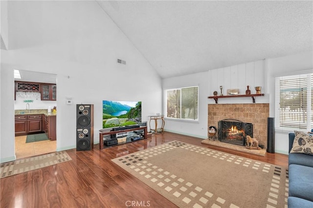 20043 Emerald Meadow Dr, Walnut, CA 91789 - living area featuring high vaulted ceiling, wood finished floors, a warm lit fireplace, and plenty of natural light