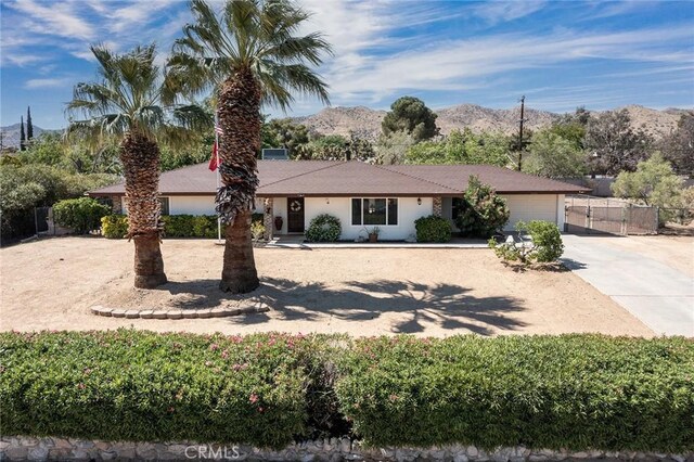 56643 Bonanza Dr, Yucca Valley, CA 92284 - single story home with concrete driveway, a mountain view, and an attached garage