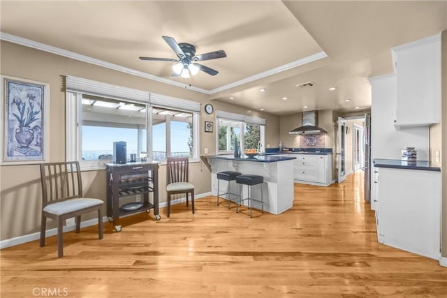 1512 Camino Lindo, South Pasadena, CA 91030 - kitchen with wall chimney exhaust hood, dark countertops, white cabinetry, a peninsula, and ornamental molding