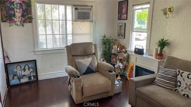 8933 Bowman Ave, South Gate, CA 90280 - living area featuring a textured wall, plenty of natural light, wood finished floors, a wall mounted air conditioner, and baseboards