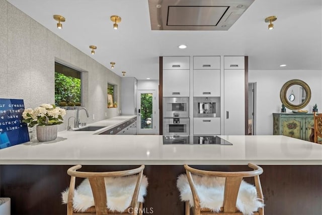 541 1st St, Manhattan Beach, CA 90266 - kitchen featuring a sink, black electric stovetop, light countertops, white cabinetry, and double oven