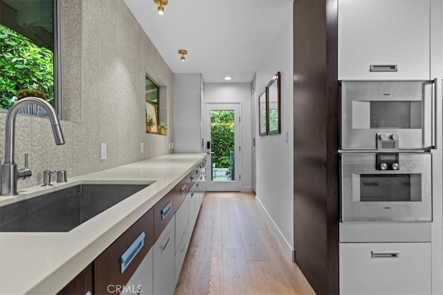 541 1st St, Manhattan Beach, CA 90266 - kitchen with a sink, light wood-style floors, light countertops, baseboards, and recessed lighting
