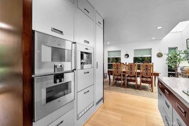 541 1st St, Manhattan Beach, CA 90266 - kitchen featuring modern cabinets, light wood-type flooring, light countertops, recessed lighting, and stainless steel microwave