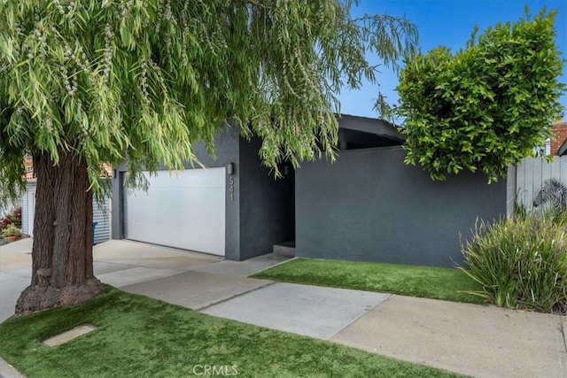 541 1st St, Manhattan Beach, CA 90266 - view of front facade with a garage, concrete driveway, stucco siding, and a front lawn