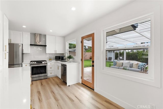 3145 Sicily Ave, Costa Mesa, CA 92626 - kitchen featuring stainless steel appliances, wall chimney range hood, light wood finished floors, white cabinets, and recessed lighting