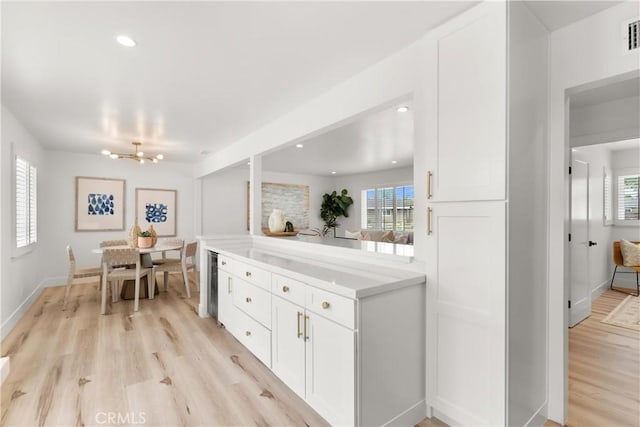 3145 Sicily Ave, Costa Mesa, CA 92626 - kitchen with white cabinetry, light wood finished floors, healthy amount of natural light, light countertops, and recessed lighting
