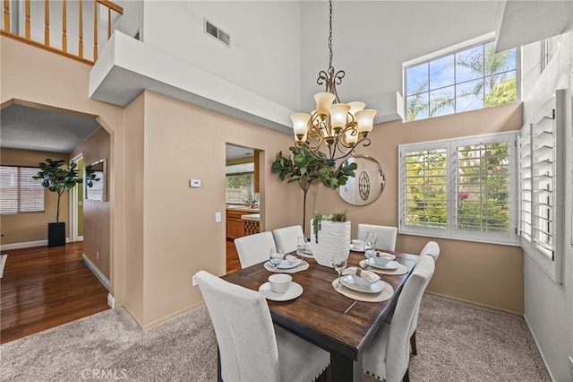 14252 Parkside Ct, Chino Hills, CA 91709 - dining space with a chandelier, arched walkways, carpet flooring, a high ceiling, and baseboards