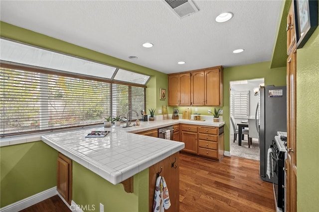 14252 Parkside Ct, Chino Hills, CA 91709 - kitchen featuring gas stove, a peninsula, dark wood-type flooring, baseboards, and tile countertops