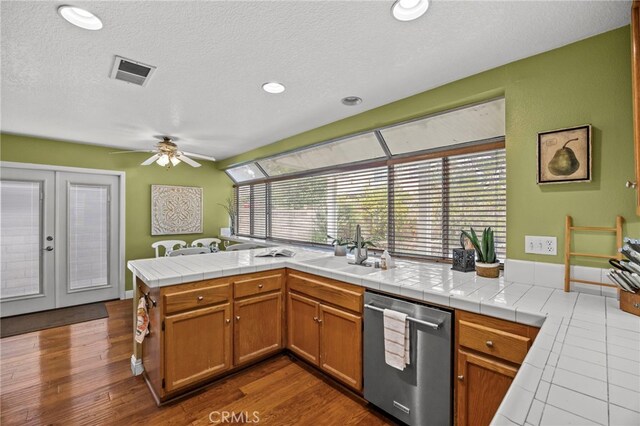 14252 Parkside Ct, Chino Hills, CA 91709 - kitchen featuring stainless steel dishwasher, a sink, french doors, ceiling fan, and brown cabinets