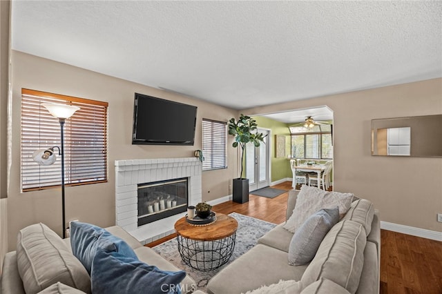 14252 Parkside Ct, Chino Hills, CA 91709 - living area featuring a ceiling fan, baseboards, a textured ceiling, a fireplace, and wood finished floors
