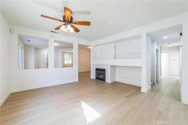 1172 Cedar Hollow Rd, Beaumont, CA 92223 - unfurnished living room with light wood-type flooring, ceiling fan, and a glass covered fireplace