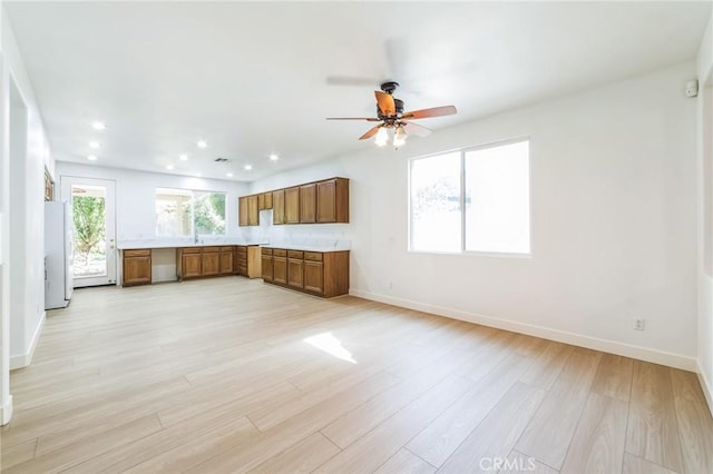 1172 Cedar Hollow Rd, Beaumont, CA 92223 - kitchen featuring brown cabinetry, freestanding refrigerator, light countertops, light wood finished floors, and a ceiling fan