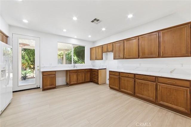 1172 Cedar Hollow Rd, Beaumont, CA 92223 - kitchen featuring white fridge with ice dispenser, brown cabinets, light countertops, and recessed lighting