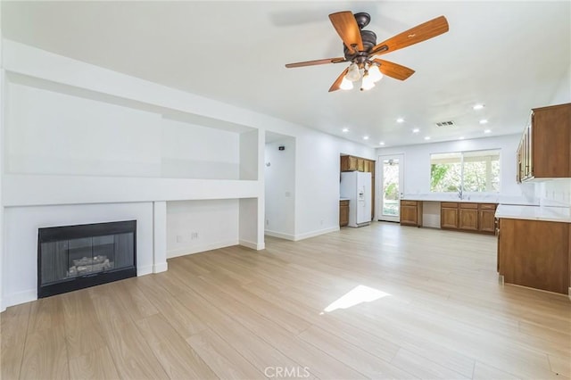 1172 Cedar Hollow Rd, Beaumont, CA 92223 - unfurnished living room featuring light wood finished floors, a ceiling fan, recessed lighting, and a glass covered fireplace