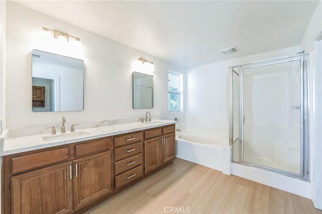 1172 Cedar Hollow Rd, Beaumont, CA 92223 - full bathroom featuring double vanity, a garden tub, a stall shower, and wood finished floors