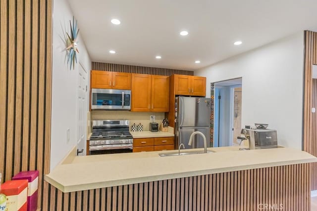 18350 Hatteras St Unit 169, Tarzana, CA 91356 - kitchen featuring stainless steel appliances, a sink, a peninsula, recessed lighting, and light countertops