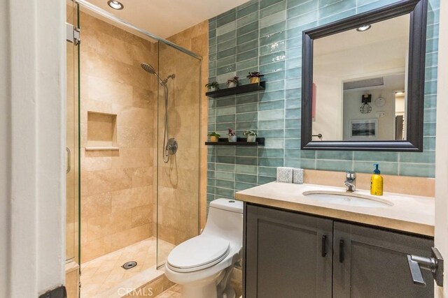 18350 Hatteras St Unit 169, Tarzana, CA 91356 - full bathroom with tile walls, toilet, vanity, a stall shower, and decorative backsplash
