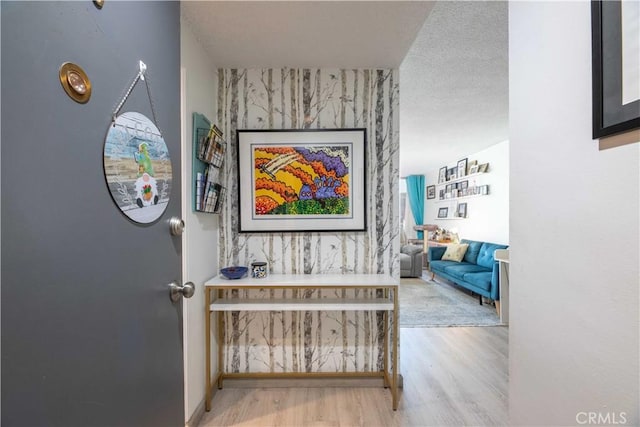 100 Atlantic Ave Unit 603, Long Beach, CA 90802 - hall featuring an accent wall, wood finished floors, wallpapered walls, and a textured ceiling