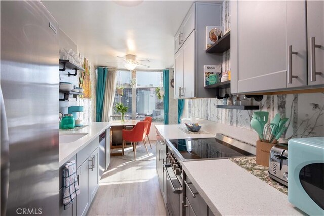 100 Atlantic Ave Unit 603, Long Beach, CA 90802 - kitchen featuring open shelves, stainless steel appliances, light countertops, light wood-style flooring, and gray cabinetry