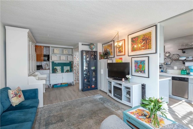 100 Atlantic Ave Unit 603, Long Beach, CA 90802 - living area featuring light wood-type flooring, a textured ceiling, and a chandelier