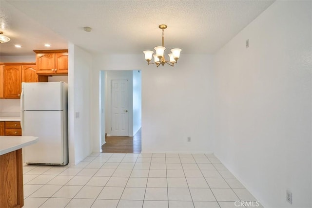 10249 Candlewood St, Rancho Cucamonga, CA 91730 - kitchen with freestanding refrigerator, light countertops, a chandelier, decorative light fixtures, and brown cabinetry